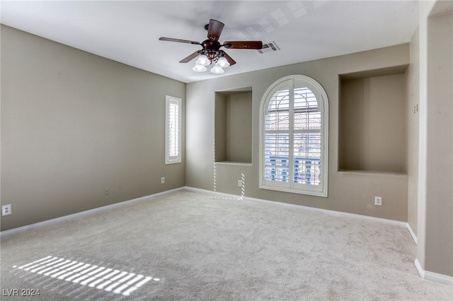 carpeted spare room with ceiling fan