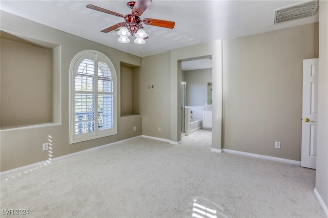 spare room featuring ceiling fan and light carpet