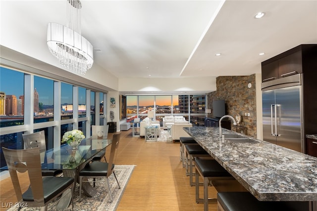 dining area with an inviting chandelier, light wood-type flooring, and sink