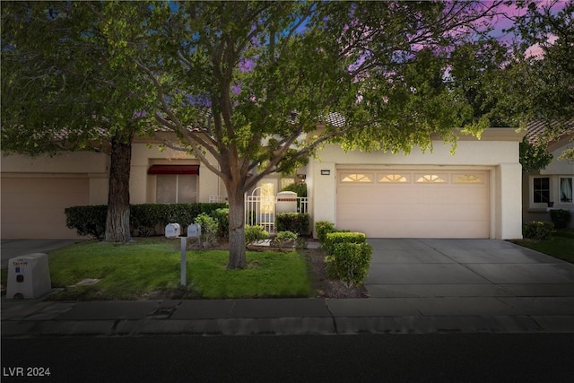 view of front of property with a garage and a yard