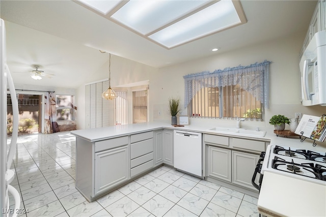 kitchen with pendant lighting, kitchen peninsula, white appliances, and a wealth of natural light