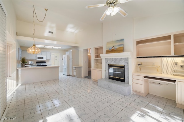 kitchen featuring a premium fireplace, high vaulted ceiling, backsplash, white appliances, and decorative light fixtures