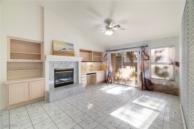 unfurnished living room with ceiling fan, high vaulted ceiling, and a high end fireplace