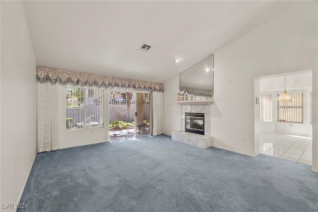 unfurnished living room featuring carpet, vaulted ceiling, and a tile fireplace