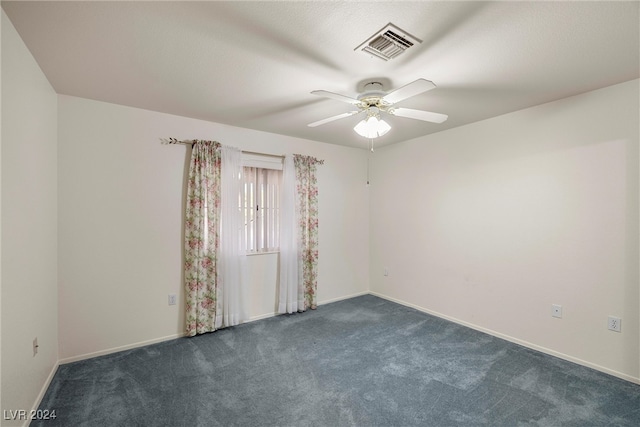 carpeted spare room featuring ceiling fan