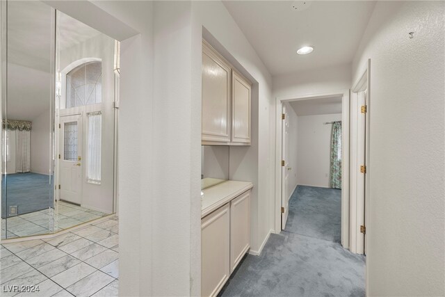 hallway featuring light colored carpet