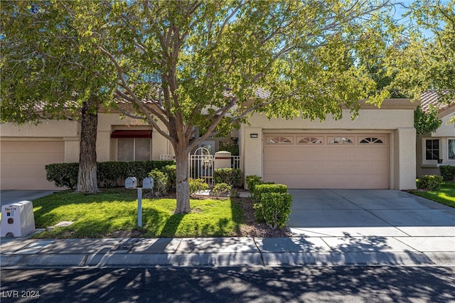 view of front of house featuring a garage and a front lawn