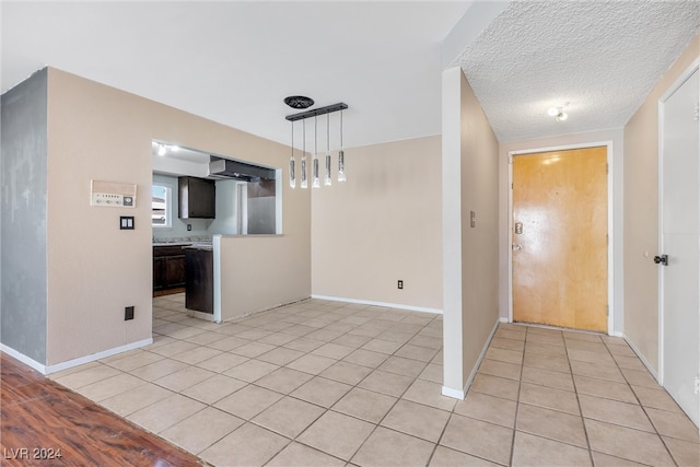 foyer entrance featuring a textured ceiling and light tile patterned floors