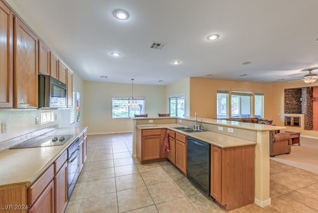 kitchen featuring pendant lighting, plenty of natural light, black appliances, and sink