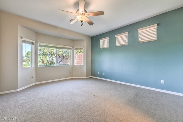 empty room featuring ceiling fan, a healthy amount of sunlight, and carpet