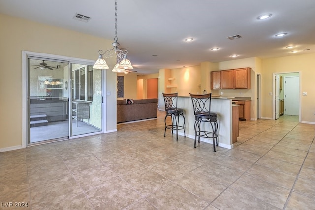 kitchen featuring a breakfast bar area, decorative light fixtures, and light tile patterned floors