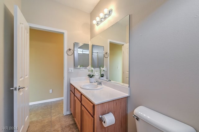 bathroom featuring vanity, tile patterned flooring, and toilet