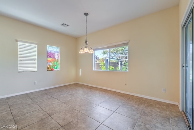 unfurnished room featuring light tile patterned flooring and an inviting chandelier