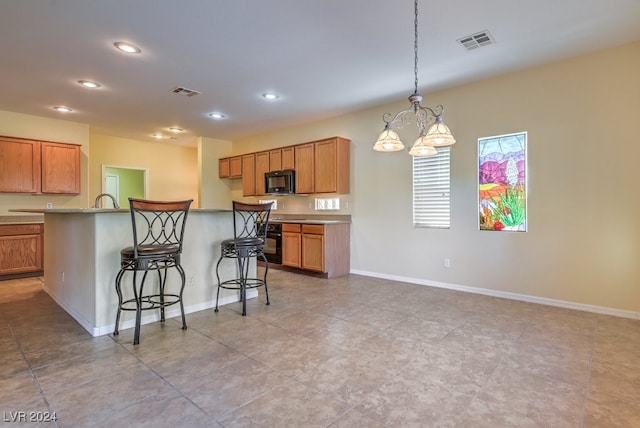 kitchen with light tile patterned flooring, a kitchen bar, decorative light fixtures, and a notable chandelier