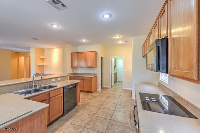 kitchen with black appliances, sink, and light tile patterned flooring