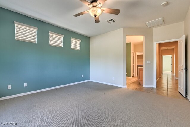 carpeted spare room with ceiling fan