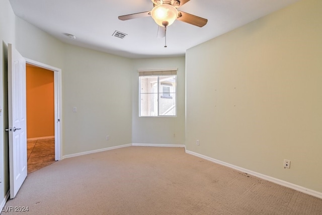 carpeted spare room with ceiling fan