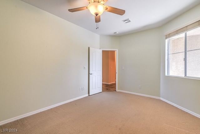 empty room featuring light carpet and ceiling fan