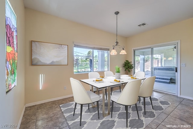 dining space with light tile patterned floors and a chandelier