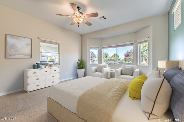 bedroom with light colored carpet, multiple windows, and ceiling fan