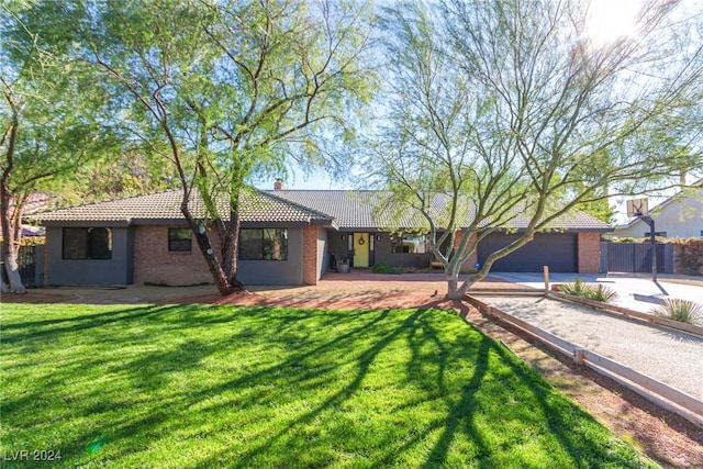 single story home featuring a front lawn and a garage