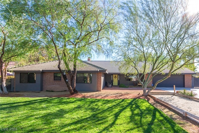 single story home with a garage and a front lawn