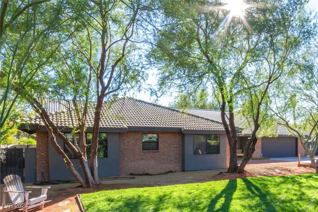 ranch-style home featuring a front lawn and a garage