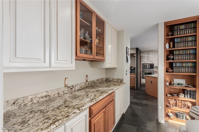 kitchen with white cabinetry, light stone countertops, and stainless steel appliances