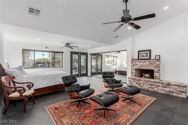 bedroom featuring ceiling fan, lofted ceiling, french doors, and a brick fireplace