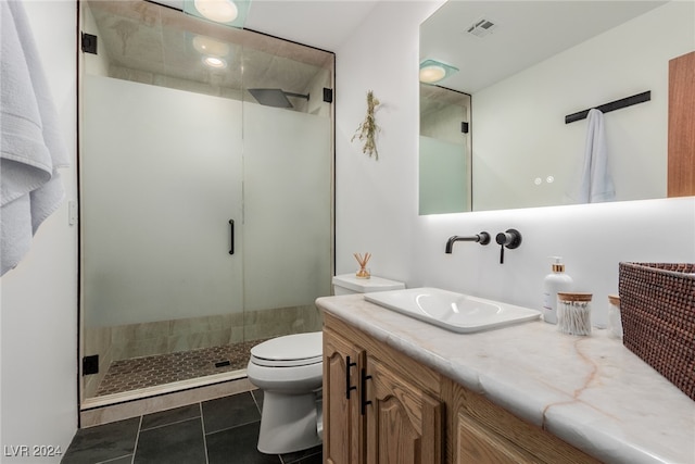 bathroom with tile patterned flooring, vanity, toilet, and walk in shower