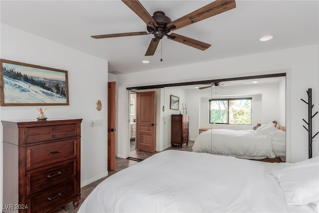 bedroom featuring connected bathroom, dark hardwood / wood-style floors, and ceiling fan