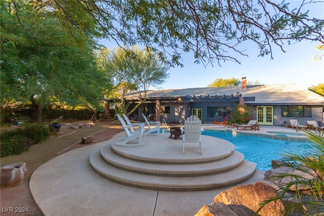 view of swimming pool featuring a patio area, an in ground hot tub, and french doors