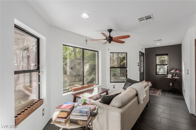 living room featuring ceiling fan and dark hardwood / wood-style floors