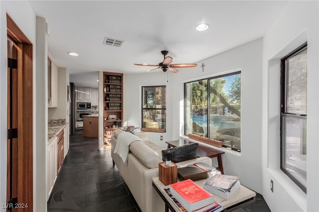 living room featuring dark hardwood / wood-style flooring and ceiling fan