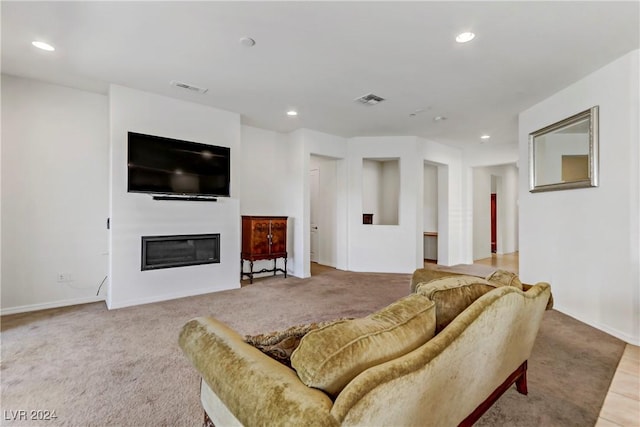 living room with a glass covered fireplace, visible vents, carpet flooring, and recessed lighting