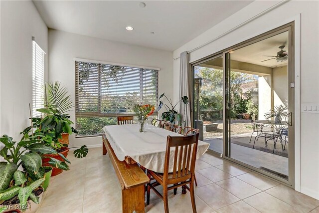 tiled dining space featuring plenty of natural light and ceiling fan