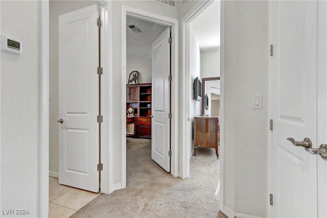 hallway featuring light carpet and visible vents