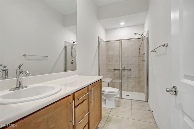 bathroom featuring toilet, a shower stall, vanity, and tile patterned floors