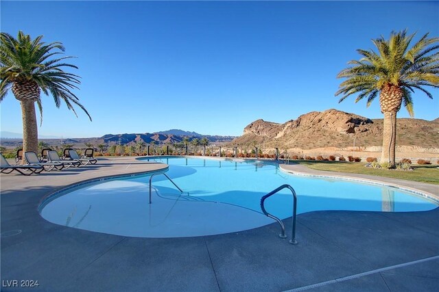 view of swimming pool with a mountain view and a patio