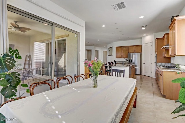 dining room with sink, light tile patterned floors, and ceiling fan