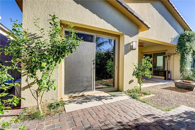 entrance to property featuring a patio and stucco siding