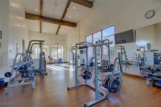 workout area with hardwood / wood-style floors and a high ceiling