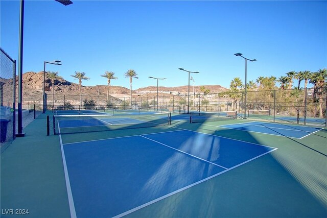 view of sport court with a mountain view and basketball hoop