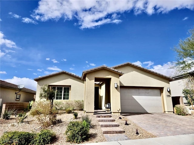 view of front of property with a garage, decorative driveway, and stucco siding