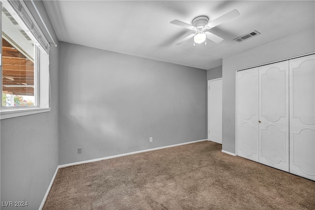 unfurnished bedroom with ceiling fan, a closet, and carpet