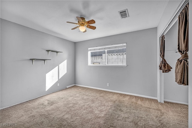 carpeted empty room featuring ceiling fan