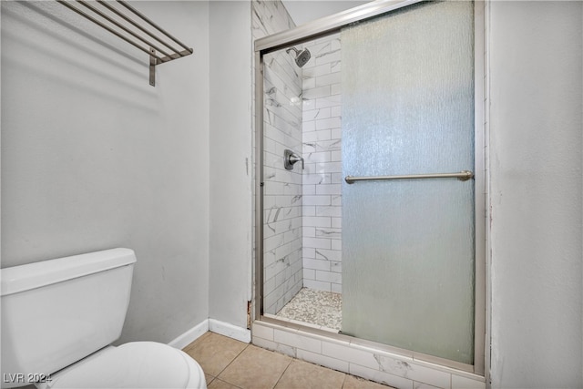 bathroom featuring a shower with shower door, tile patterned flooring, and toilet