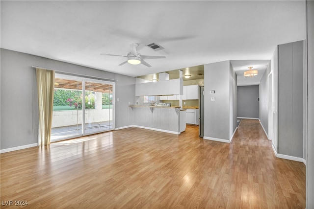 unfurnished living room featuring light wood-type flooring and ceiling fan