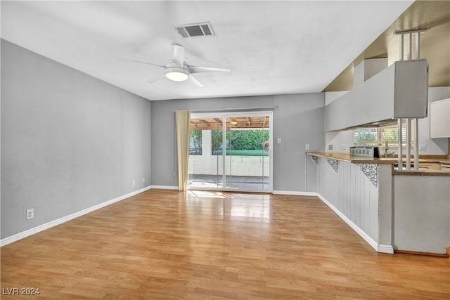 unfurnished living room with light wood-type flooring and ceiling fan