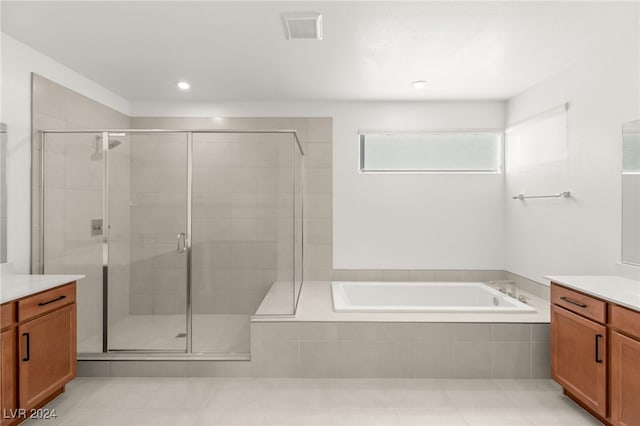 bathroom featuring independent shower and bath, vanity, and tile patterned floors